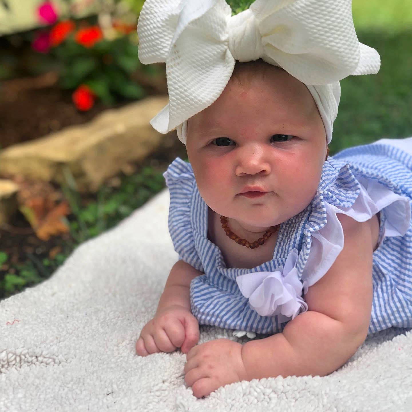 Nevaeh joined the competition — help win amazing prizes! baby, baby_toddler_clothing, bonnet, child, child_model, clothing, ear, fashion_accessory, grass, hair_accessory, hat, head, headgear, headwear, person, photography, pink, plant, product, skin