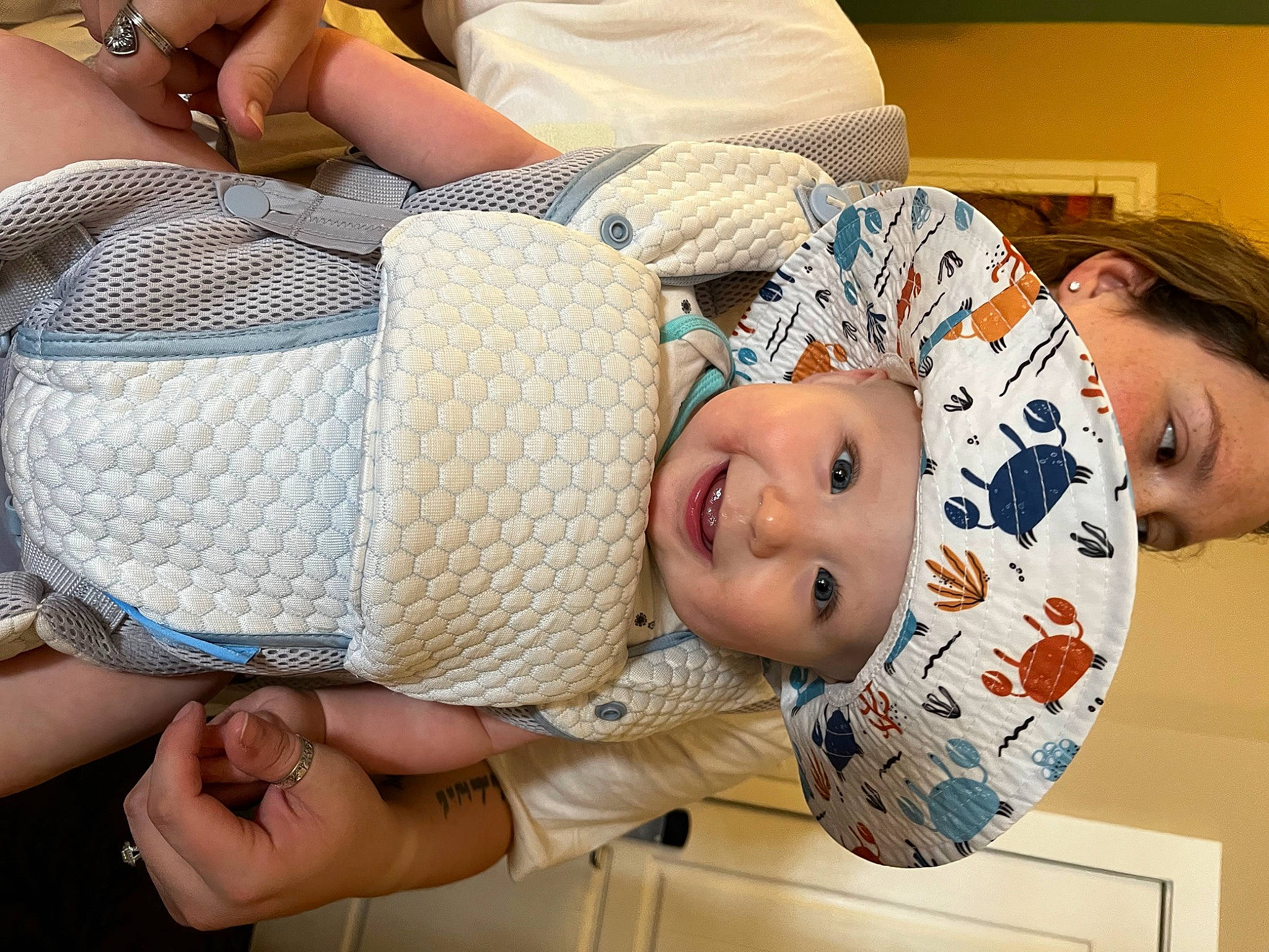 Colten is registered to the contest to win money with this photo: abdomen, arm, baby, baby_toddler_clothing, cheek, chest, comfort, elbow, finger, gesture, hand, happy, hat, headwear, joint, joy, mouth, person, smile, stomach