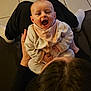 baby, infant, smiling, laughing, person, indoor, floor, clothing, sitting, adult, lap, happy, cozy, tiled_floor, head, hands, warm_light, casual, bonding, family