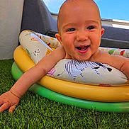 Marius a rejoint le concours — aidez-le/la à gagner de superbes lots ! baby, infant, smile, tooth, arm, inflatable_ring, pool_toy, grass, lawn, outdoor, sky, blue_sky, couch, face, close_up, happy, playful, summer, cute, portrait