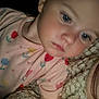 Eliza is registered to the contest to win money with this photo: blanket, blue_eyes, child, close_up, cozy, cute, expression, face, flower_pattern, indoor, infant, person, pink_shirt, portrait, resting, skin, sleeve, soft_lighting, toddler, young_child
