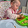 baby, cereal, child, face, feeding, food, green_spoon, hair, hand, high_chair, indoor, mealtime, messy, person, pink_clothing, plate, spaghetti, table, toddler, unicorn_pattern