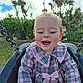 baby, bow, checkered, child, clouds, collar, dress, face, grass, gray, happy, outdoor, park, person, pink, playground, sky, smile, swing, trees