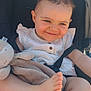 Judith a rejoint le concours — aidez-le/la à gagner de superbes lots ! baby, child, stroller, white_dress, plush_toy, blanket, foot, smile, happy, cute, infant, seatbelt, outdoor, sunlight, skin, face, person, clothing, head, relaxing