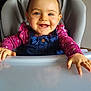 baby, child, smiling, high_chair, denim_overalls, pink_shirt, indoor, face, hands, happy, cute, infant, table, blue_eyes, person, toddler, furniture, portrait, clothing, skin