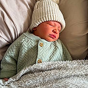 Freddie joined the competition — help win amazing prizes! newborn, baby, sleeping, knit_hat, pom_pom, blanket, soft_texture, pillow, cozy, infant, peaceful, cute, warm_clothing, indoors, resting, close_up, portrait, child, sleep, comfort