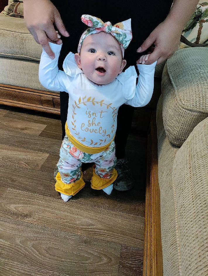 Gabriella is registered to the contest to win money with this photo: arm, baby, baby_toddler_clothing, child, event, finger, flooring, gesture, grass, hand, happy, hat, head, headwear, pattern, person, skin, sleeve, smile, surprise