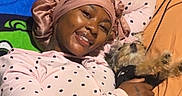 Amber Ferrari is registered to the contest to win money with this photo: person, dog, small_dog, smiling, bedroom, bed, pajamas, bonnet, polka_dots, blanket, pillow, cuddling, pet, indoors, portrait, cozy, bedding, wood_paneling, charger_cable, tattoo