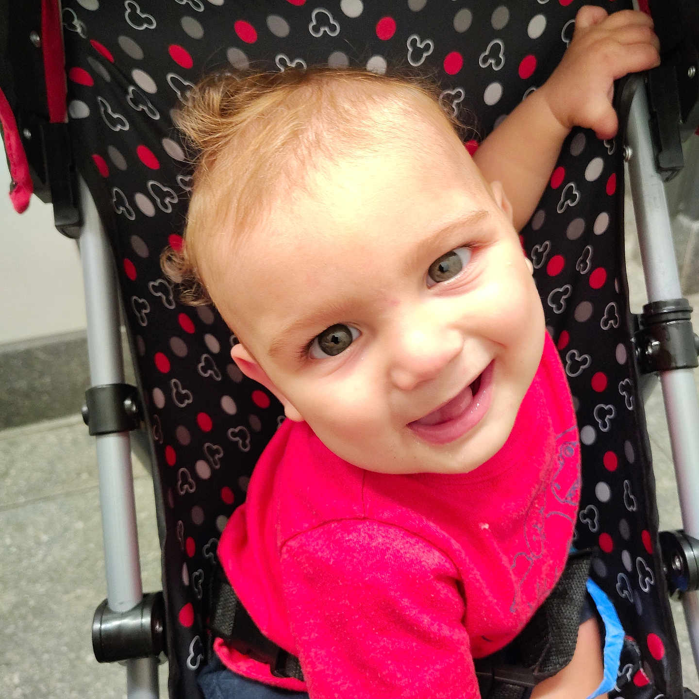 Luther joined the competition — help win amazing prizes! baby, child, toddler, stroller, smiling, happy, portrait, face, eyes, blonde_hair, pink_shirt, seated, indoor, patterned_fabric, polka_dots, baby_carriage, hand, playful, close_up, photography