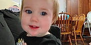 Hazel joined the competition — help win amazing prizes! baby, black_shirt, blanket, blue_eyes, cabinet, child, couch, curtain, cute, face, floor, furniture, hair, indoor, person, pony_tail, smiling, toddler, unicorn, wooden_chair