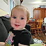 Hazel joined the competition — help win amazing prizes! toddler, child, indoor, unicorn, black_shirt, pony_tail, couch, wooden_chair, cabinet, floor, curtain, face, smiling, blue_eyes, furniture, blanket, person, hair, cute, baby