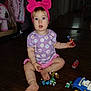 Hazel is registered to the contest to win money with this photo: blue_eyes, child, clothing, cute, daisy_pattern, door, expression, floor, foot, hand, indoor, living_room, pink_bow, plastic_toys, playtime, purple_shirt, sitting, toddler, toy, wooden_floor