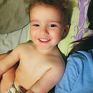David joined the competition — help win amazing prizes! toddler, child, smiling, face, bare_chest, diaper, blanket, pattern, hair, joyful, person, indoors, lying_down, closeup, happy, skin, head, shoulder, blue_shirt, candid