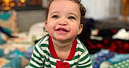 Ariyah joined the competition — help win amazing prizes! baby, child, smiling, pajamas, striped_clothing, indoor, fireplace, cozy, holiday, curly_hair, crawling, polka_dot, cushion, cheerful, portrait, warm_lighting, home_interior, window, furniture, happy