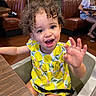 Ariyah joined the competition — help win amazing prizes! toddler, child, curly_hair, high_chair, dress, lemon_pattern, smiling, happy, restaurant, table, wooden_table, booth_seating, leather_seat, indoor, person, face, eyes, mouth, hand, colorful_painting