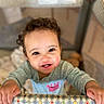 Ariyah is registered to the contest to win money with this photo: toddler, child, smiling, curly_hair, baby_clothes, playpen, indoor, happy, portrait, cute, infant, holding, colorful, patterned, grip, bright_eyes, young_child, face, person, closeup