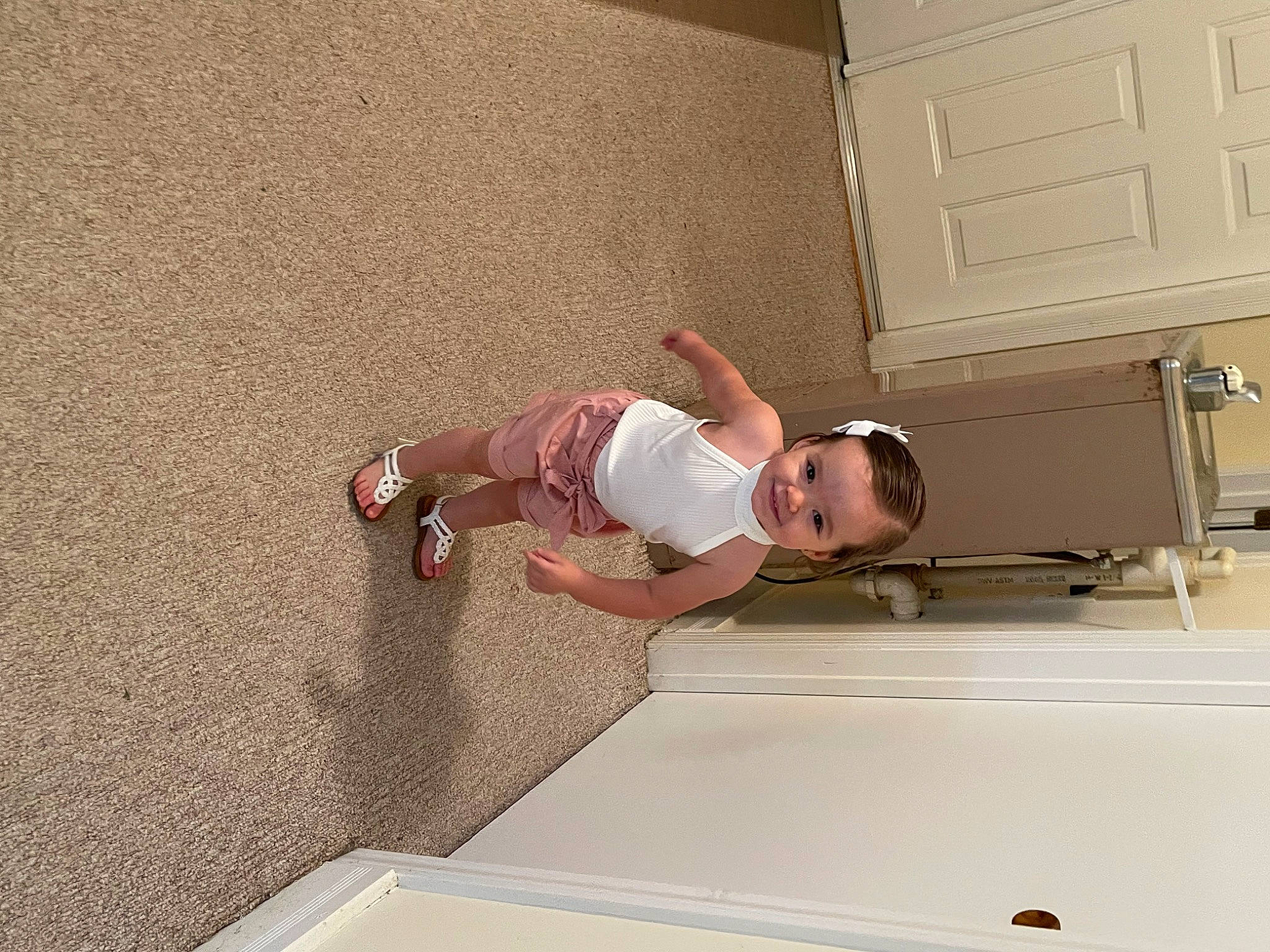 Tatum is registered to the contest to win money with this photo: baby, baby_toddler_clothing, child, comfort, door, elbow, flooring, fun, hardwood, house, human_body, human_leg, joy, knee, leisure, person, room, shorts, t_shirt, thigh