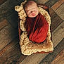 newborn, baby, sleeping, swaddle, blanket, knit, wooden_tray, floor, rustic, cozy, infant, wrapped, peaceful, indoors, portrait, cute, soft, child, resting, homedecor