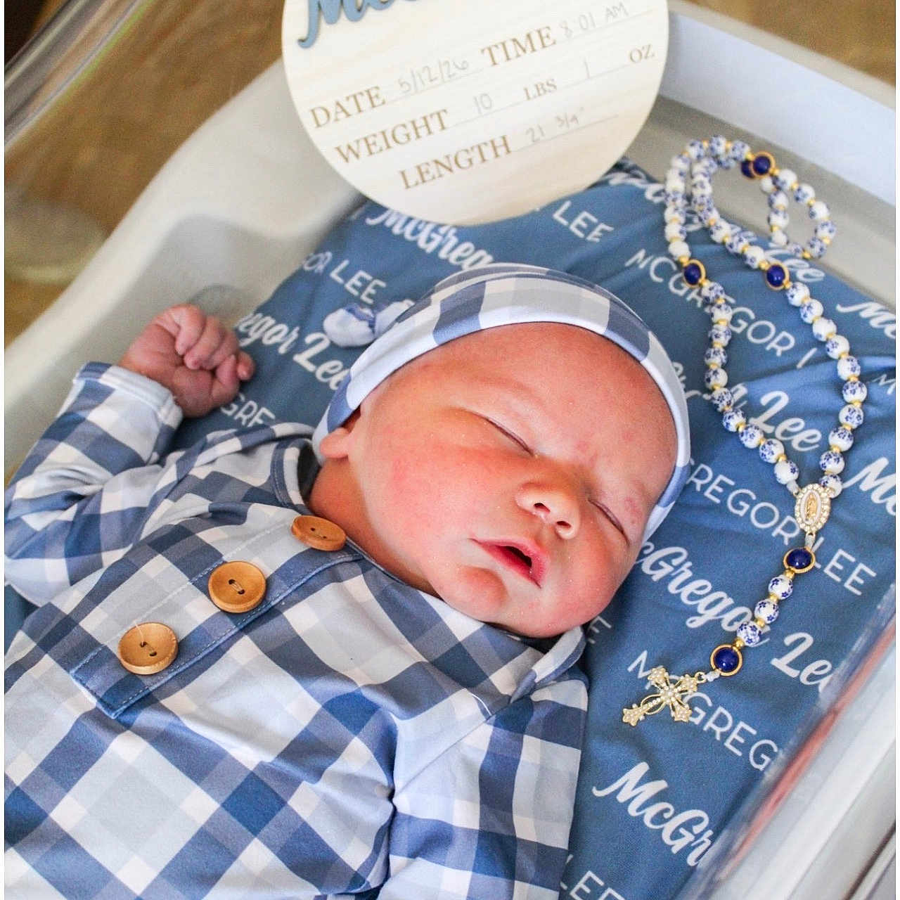 Mcgregor joined the competition — help win amazing prizes! baby, newborn, sleeping, infant, bassinet, blanket, rosary, clothing, hat, wooden_sign, birth_announcement, hospital, peaceful, portrait, closeup, blue, white, pattern, cute, resting