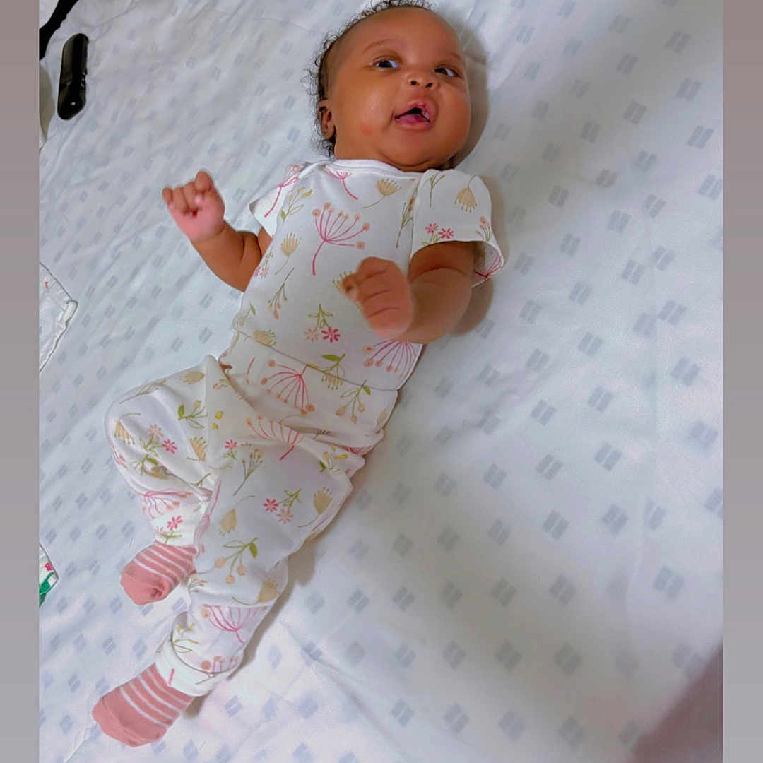 Zariyy joined the competition — help win amazing prizes! baby, bed, blanket, child, curious, cute, floral_pattern, happy, indoors, infant, lying_down, newborn, pajamas, person, pink_socks, sleepwear, small_hands, smiling, soft_light, white