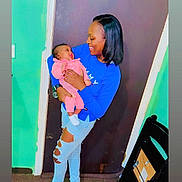 Zariyy joined the competition — help win amazing prizes! woman, baby, indoor, holding, smiling, blue_sweater, pink_clothing, ripped_jeans, door, carpet, black_chair, happy, person, child, family, love, casual_clothing, footwear, curly_hair, short_hair
