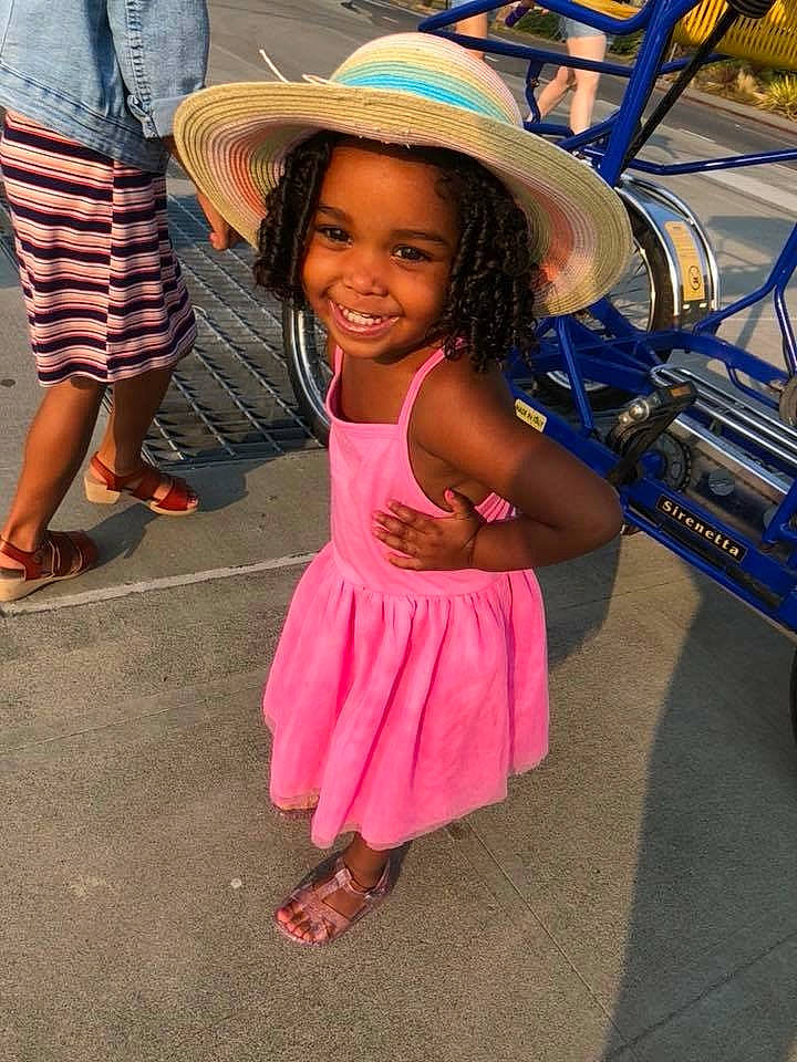 Jersie is registered to the contest to win money with this photo: abdomen, child, cool, fashion_accessory, fun, girl, happiness, headgear, joy, leg, person, pink, smile, toddler, vacation