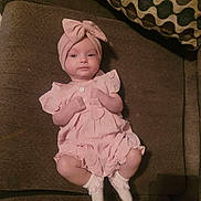 Skylar joined the competition — help win amazing prizes! baby, child, infant, portrait, sitting, couch, sofa, pink_outfit, headband, bow, dress, ruffles, socks, face, eyes, indoors, home, pillow, furniture, cute