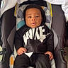 baby, infant, car_seat, black_clothing, nike, footwear, child, young_child, person, indoors, blanket, seat, cute, portrait, looking_at_camera, black_hair, small_hands, casual_wear, baby_shoes, comfortable