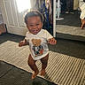 toddler, child, smiling, indoor, mirror, reflection, tshirt, skeleton, bear, carpet, door, fan, dresser, clothing, barefoot, happy, walking, room, floor, light