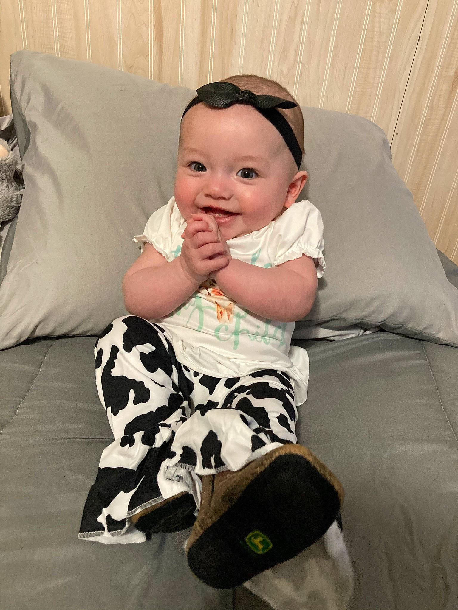 Gracelynn is registered to the contest to win money with this photo: baby, baby_toddler_clothing, child, comfort, couch, eye, happy, head, headwear, human_leg, knee, leg, pattern, person, pillow, room, sitting, sleeve, smile, sock