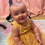 Allison is registered to the contest to win money with this photo: baby, child, smiling, yellow_dress, pigtails, fluffy_rug, pastel_colors, pink_curtain, indoor, happy, cute, portrait, infant, sitting, adorable, chubby_arms, curious, soft_lighting, closeup, person