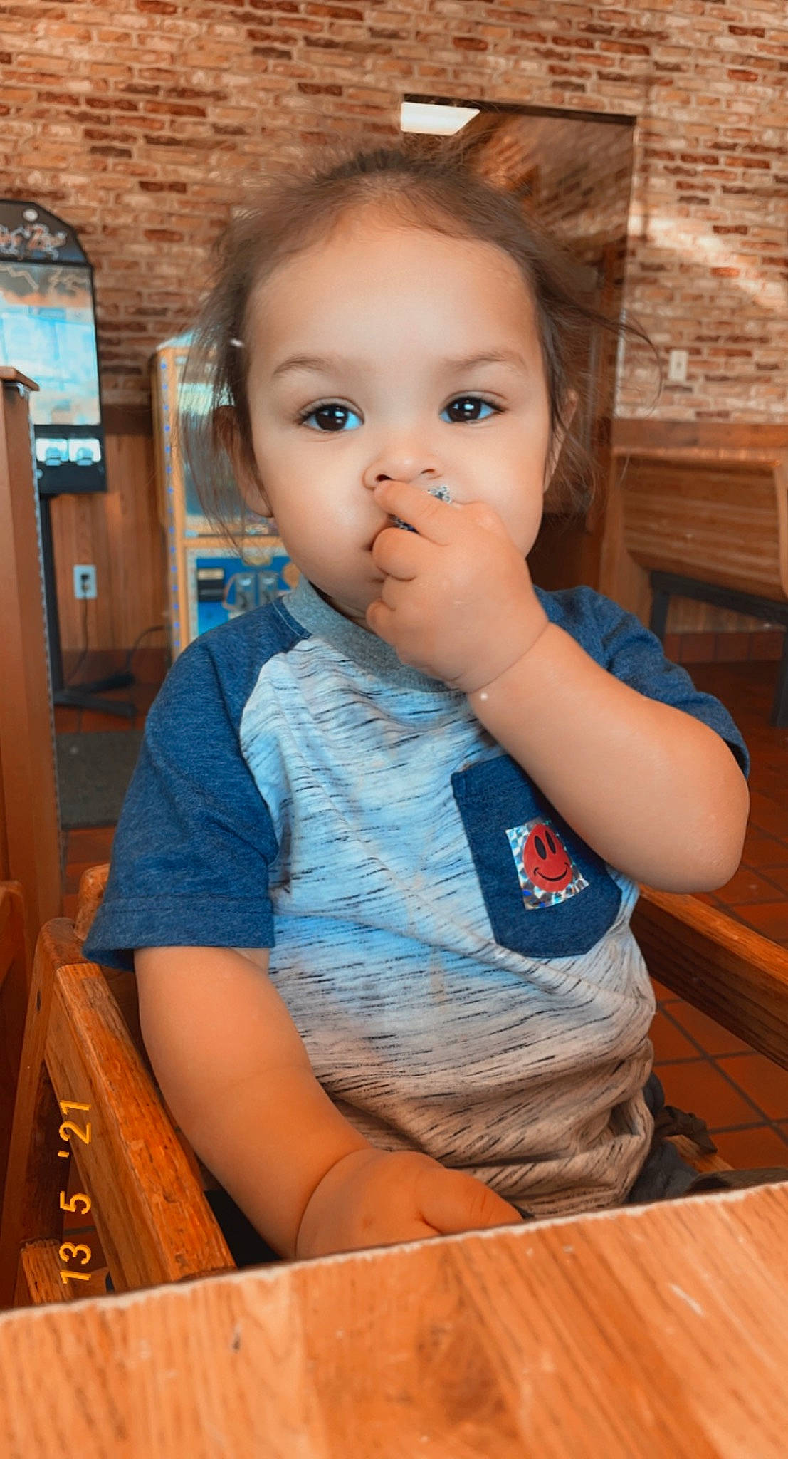 Taylen is registered to the contest to win money with this photo: baby_toddler_clothing, cheek, child, electric_blue, flooring, fun, happy, hardwood, iris, leisure, nose, person, sitting, skin, standing, summer, t_shirt, table, toddler, varnish