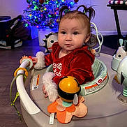 Liliana is registered to the contest to win money with this photo: activity_center, baby, child, childhood, christmas_tree, cute, decorations, festive, floor, happy, holiday, home, indoor, infant, person, pigtails, playtime, red_clothing, smiling, toys