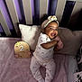 Pync is registered to the contest to win money with this photo: baby, bed, clothing, couch, crib, cushion, face, furniture, hat, head, homedecor, hosiery, indoors, infantbed, newborn, person, photography, pillow, portrait, sock