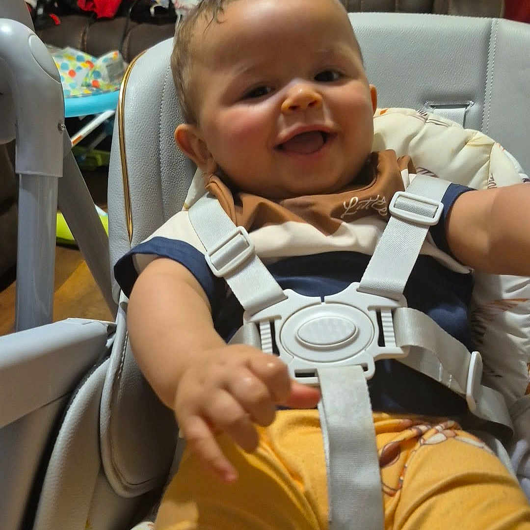 Dailier joined the competition — help win amazing prizes! baby, blanket, child, clothing, couch, cute, furniture, happy, high_chair, home, indoor, infant, living_room, person, playful, seatbelt, seated, smiling, toy, yellow_pants