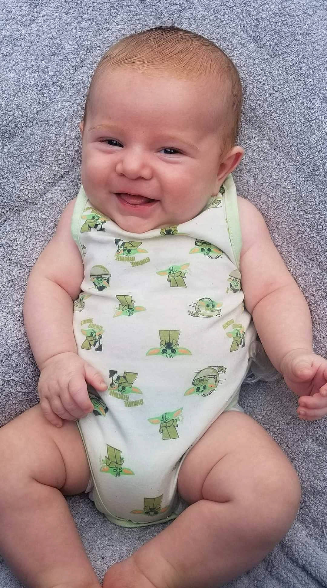 Waylon is registered to the contest to win money with this photo: baby, baby_toddler_clothing, cheek, chin, eye, face, facial_expression, finger, happy, head, human, iris, organ, person, photograph, pink, skin, sleeve, smile, stomach