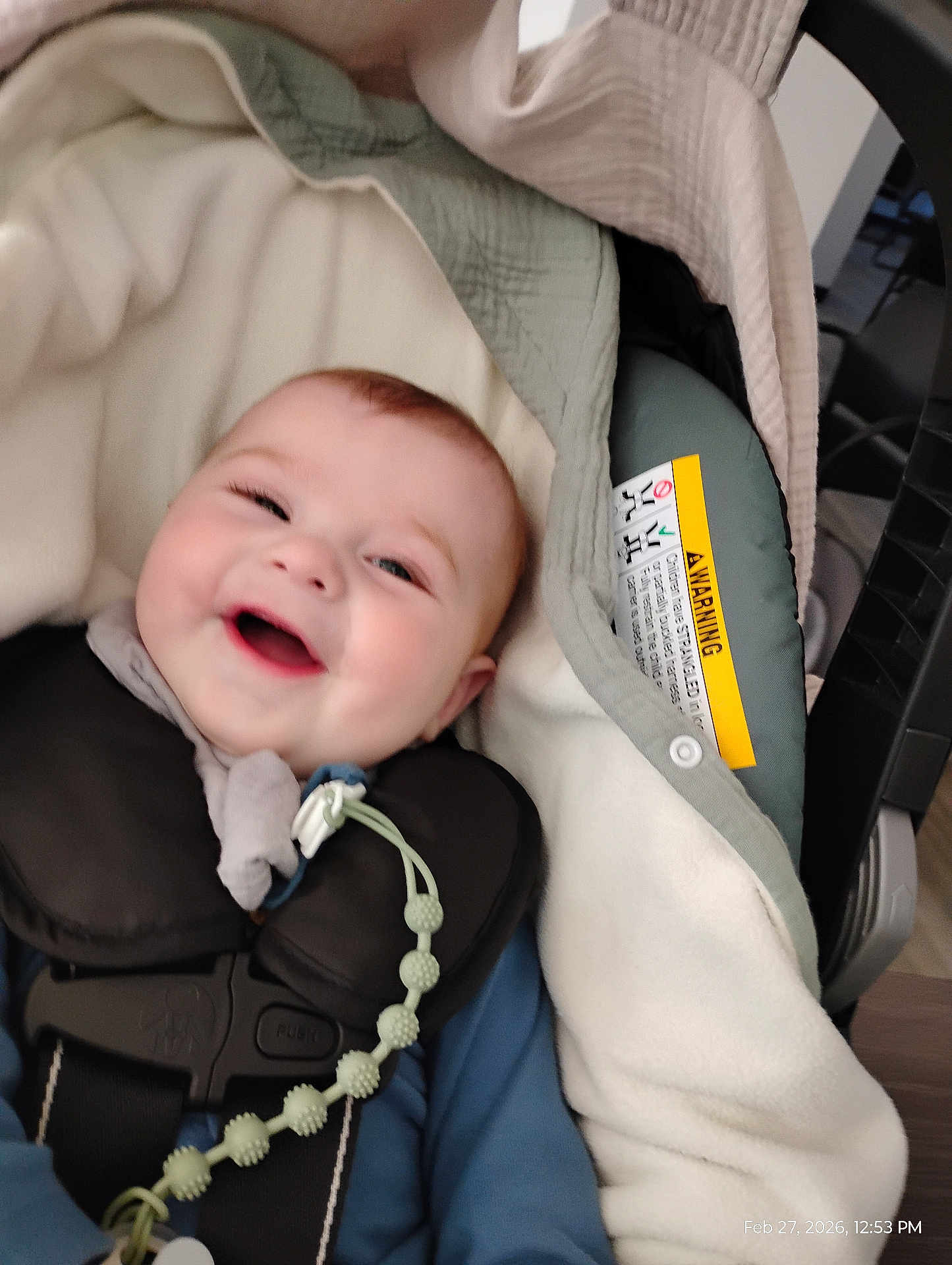 Leelynd is registered to the contest to win money with this photo: baby, infant, smiling, car_seat, harness, blanket, pacifier_clip, beaded_chain, clothing, face, cheeks, happy, head, closeup, safety_label, infant_carrier, fabric, padding, indoor, timestamp