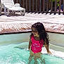 child, girl, swimming_pool, water, swimsuit, pink, smiling, wet_hair, outdoor, sunny, deck, wooden_deck, lounge_chair, relaxation, summer, vacation, happy, leisure, playful, sunlight