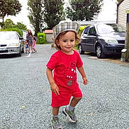 Issa a rejoint le concours — aidez-le/la à gagner de superbes lots ! toddler, child, red_clothing, hat, sneakers, gravel, outdoor, trees, car, people, adult, sidewalk, house, daylight, smiling, playful, parked_car, nature, family, casual