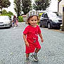 toddler, child, red_clothing, hat, sneakers, gravel, outdoor, trees, car, people, adult, sidewalk, house, daylight, smiling, playful, parked_car, nature, family, casual
