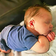 Roman is registered to the contest to win money with this photo: baby, sleeping, blue_clothing, infant, peaceful, cute, tummy, hands, face, skin, hair, closeup, soft, rest, child, newborn, portrait, indoors, comfort, relaxation