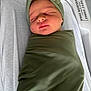 Nova is registered to the contest to win money with this photo: newborn, baby, sleeping, swaddled, headband, olive_green, blanket, hospital, nursery, bassinet, infant, peaceful, soft_lighting, face, person, closeup, resting, child, cute, portrait