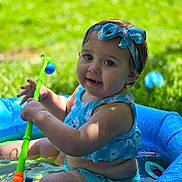 Sage is registered to the contest to win money with this photo: baby, babylaughing, clothing, face, grass, happy, head, nature, person, photography, plant, pool, portrait, sitting, smile, summer, swimmingpool, swimwear, toy, water