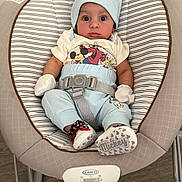 Ashton is registered to the contest to win money with this photo: baby, infant, baby_rocker, mickey_mouse, clothing, mittens, hat, shoes, striped, seat_belt, baby_seat, floor, graco, cute, wide_eyes, indoor, toddler, person, child, portrait