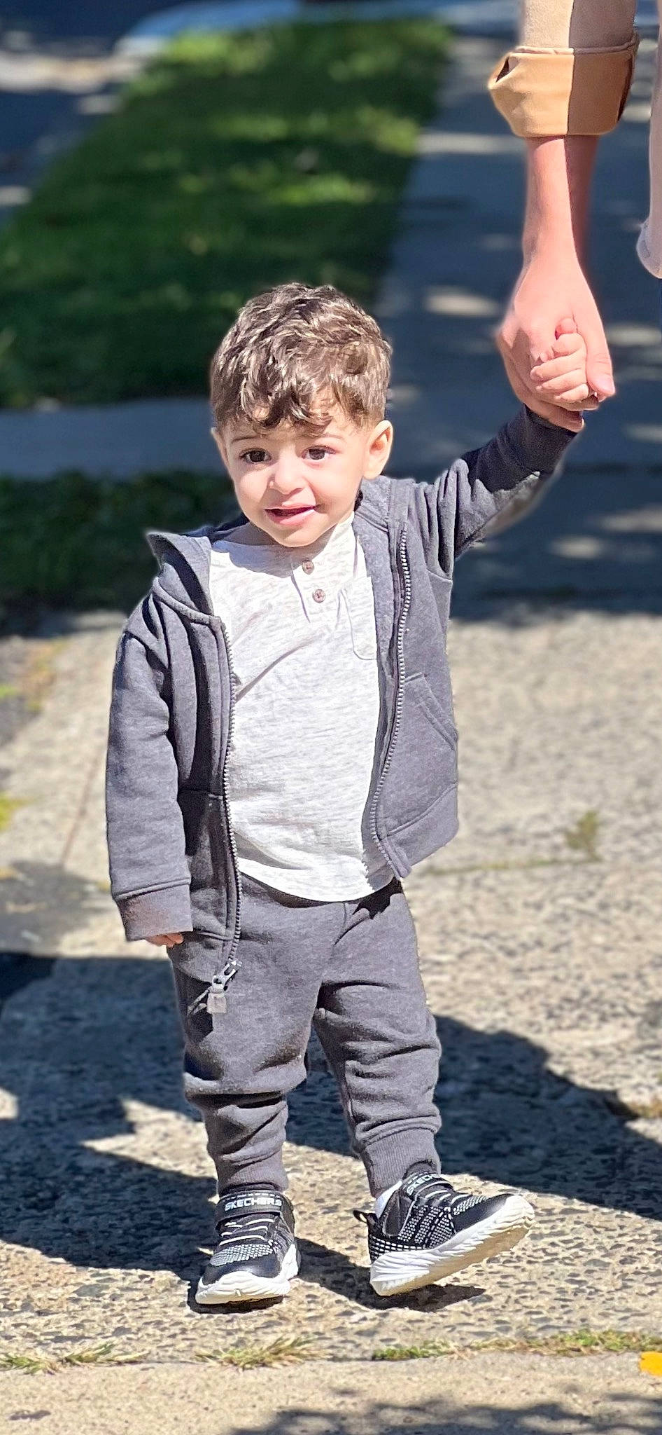 Amir is registered to the contest to win money with this photo: denim, eye, face, formal_wear, fun, gesture, grass, hair, hand, happy, head, human_body, leisure, outerwear, people_in_nature, person, recreation, sleeve, soil, toddler