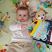 Chiara a rejoint le concours — aidez-le/la à gagner de superbes lots ! baby, book, child, clothing, colorful, cute, expression, floor, giraffe, hand, indoor, infant, lying_down, pajamas, person, playmat, plush_toy, rattle, soft_toy, toy