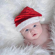 Madeline is registered to the contest to win money with this photo: baby, infant, santa_hat, red_hat, white_fur, blue_eyes, portrait, cute, christmas, holiday, fluffy, soft_texture, newborn, bare_shoulders, cheeks, gaze, close_up, cozy, studio_lighting, calm_expression