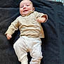 Marlon a rejoint le concours — aidez-le/la à gagner de superbes lots ! baby, child, smiling, lying_down, blanket, beige_clothing, white_pants, infant, happy, indoors, face, cute, person, young_child, cozy, kicking, head, expression, soft_texture, patterned_background