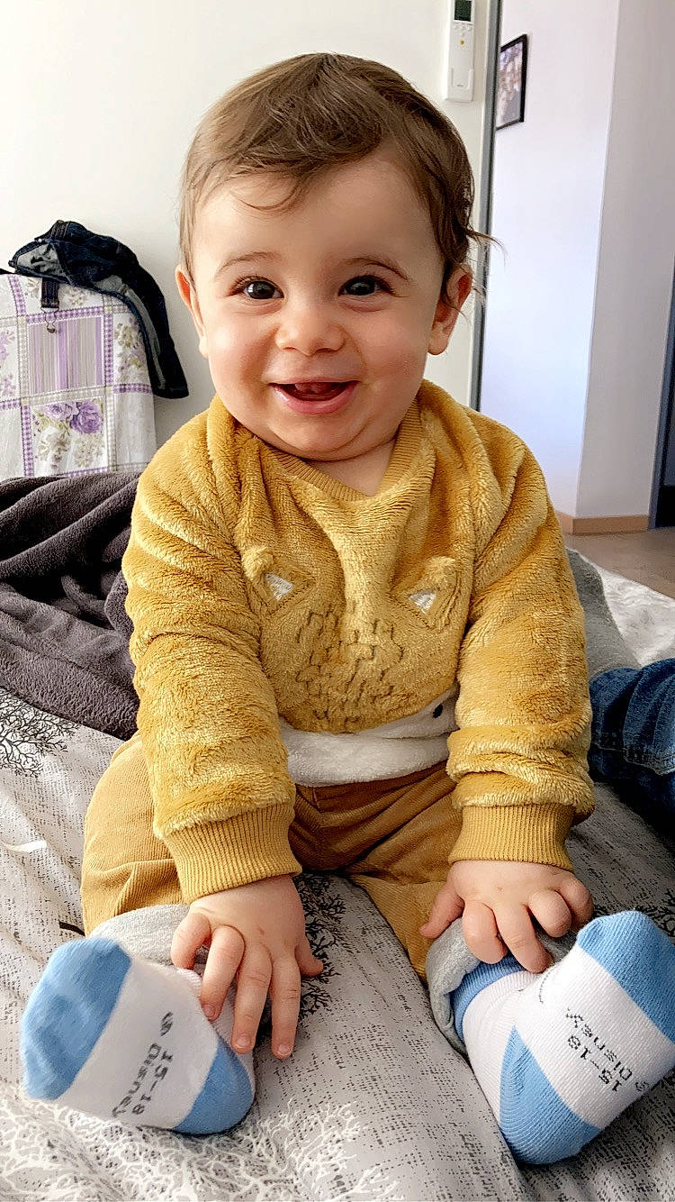 Ilyas participe au concours pour gagner de l'argent avec cette photo : baby, baby_toddler_clothing, blue, cheek, child, comfort, face, flooring, fun, hairstyle, happy, joy, pattern, person, sitting, skin, sleeve, smile, t_shirt, toddler