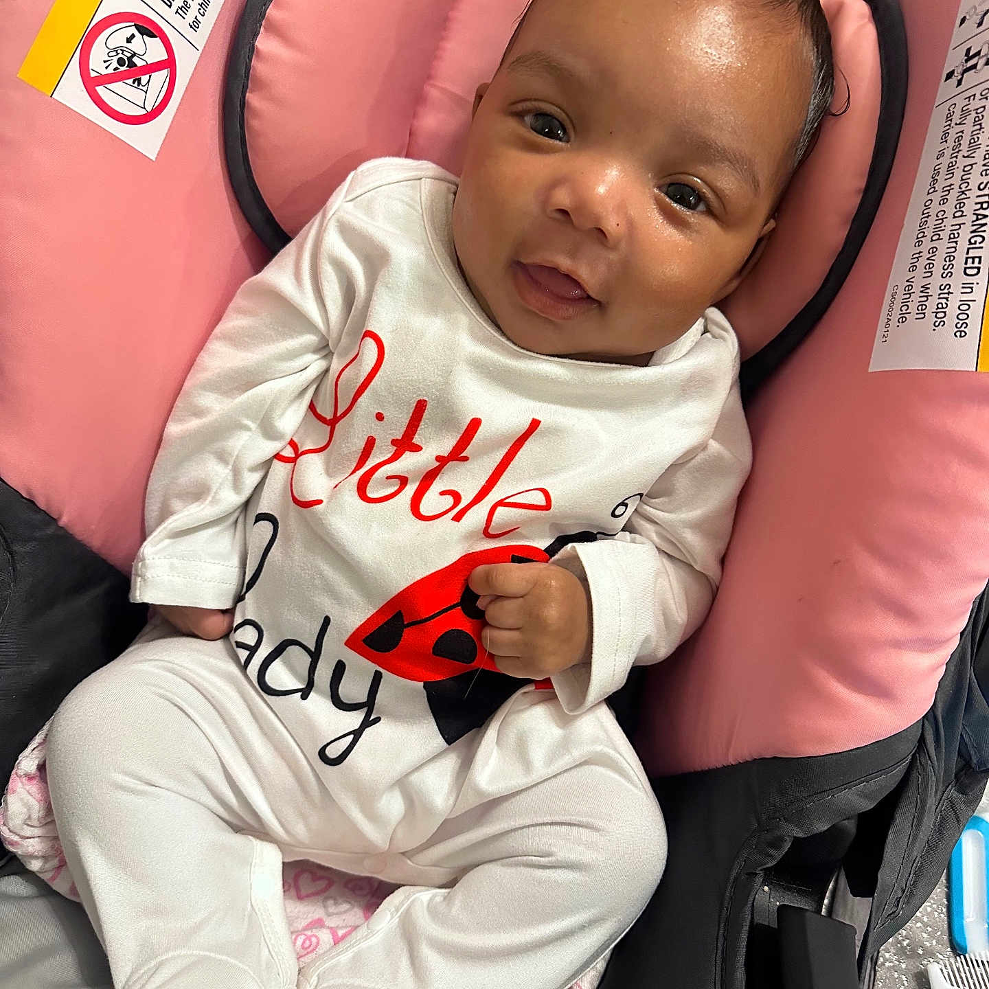 Icelynn joined the competition — help win amazing prizes! baby, infant, child, car_seat, pink, white_clothing, onesie, ladybug, cute, smile, face, head, hands, footwear, fabric, cushion, seat, indoor, portrait, person
